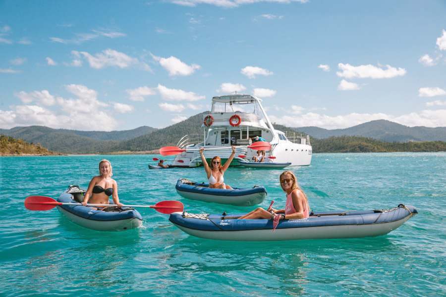 Whitsunday Kayaking Three women in kayaks infront of a catamaran