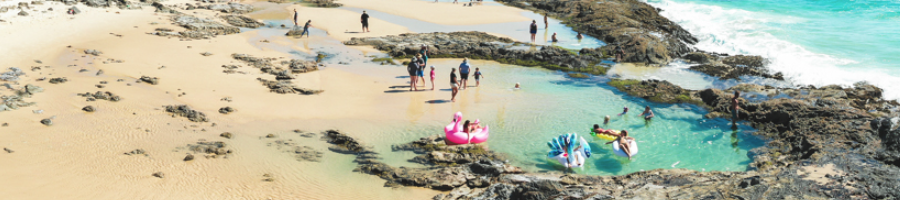 A group of people swimming in an ocean pool