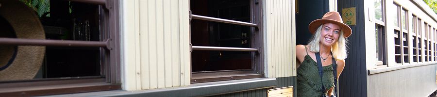 Women wearing a hat and camera smiling on the Kuranda Scenic Railway