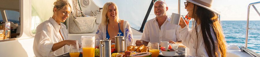 Whitsunday Blue Breakfast A group of four having breakfast aboard Whitsunday Blue in white robes