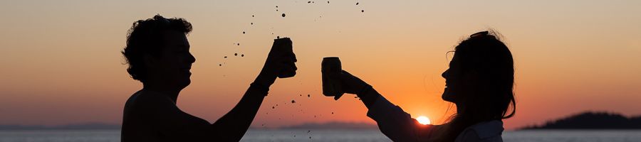 Salty Sunset Cruise Two people cheersing at golden hour