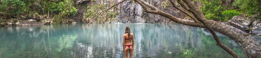 Woman standing in the blue pools of Cedar Creek in swimmers