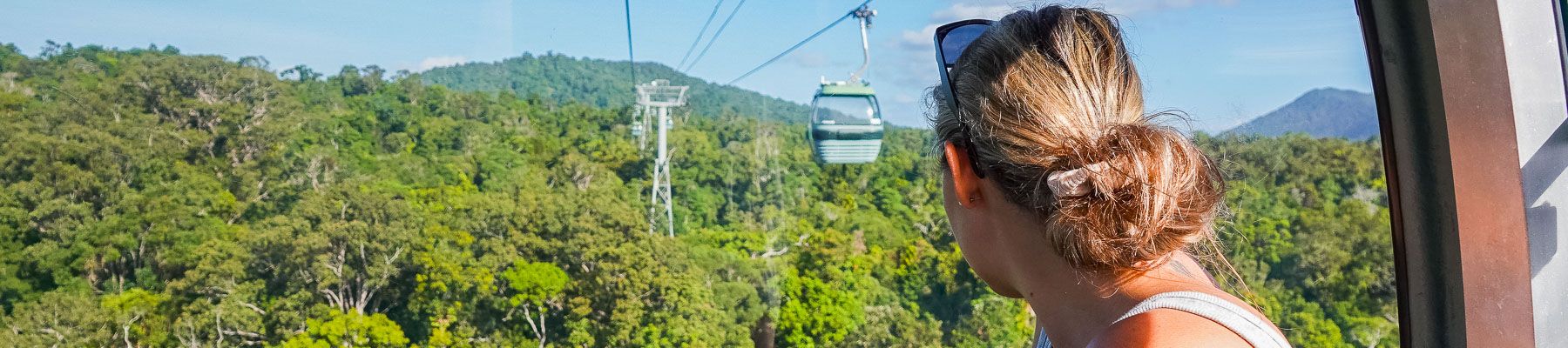 A woman on a cable car looking out over rainforest