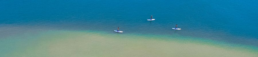 Paddleboards paddleboards drifting along bright blue water