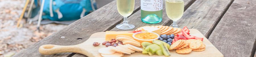 cheese board and white wine at a campsite