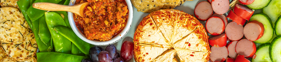 A close up image of a food platter with an assortment of cheeses and crackers