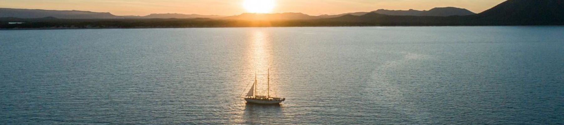 Derwent Hunter boat sailing into sunset in the Whitsundays