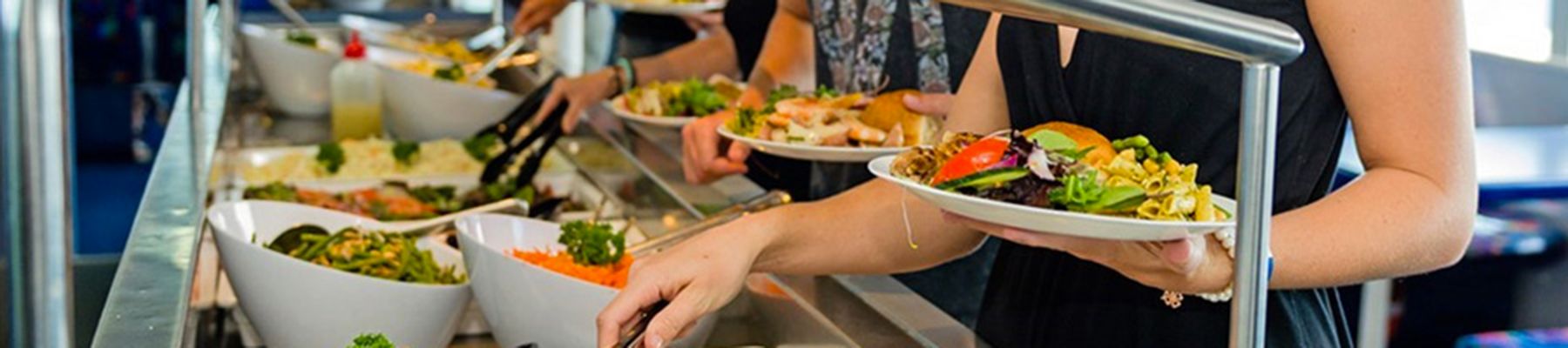 Buffet with salads, snacks and people serving themselves food 