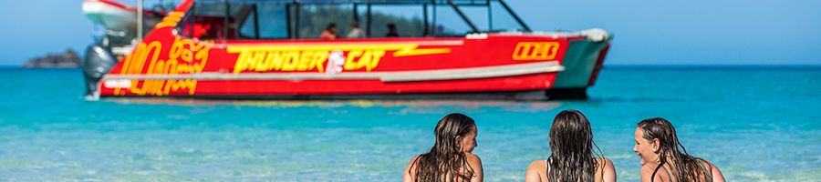 Thundercat, Whitehaven Beach Three women looking at Thundercat boat on Whitehaven Beach