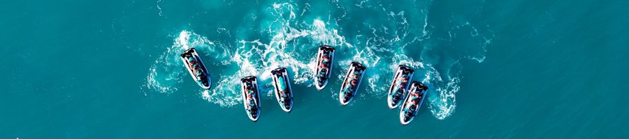 a drone shot of jetskis in the ocean all lined up
