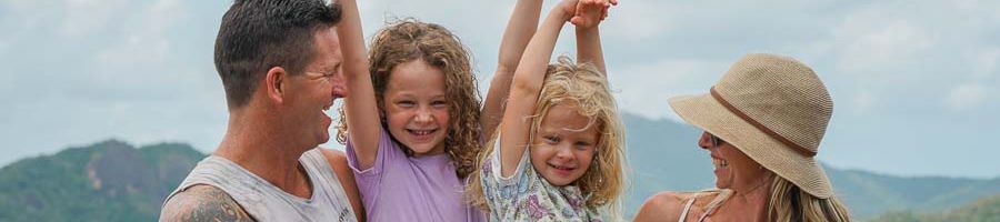 Family half-day tours, Purely Whitehaven Half-Day Tour Parents and two children in the Whitsundays throwing their hands in the air