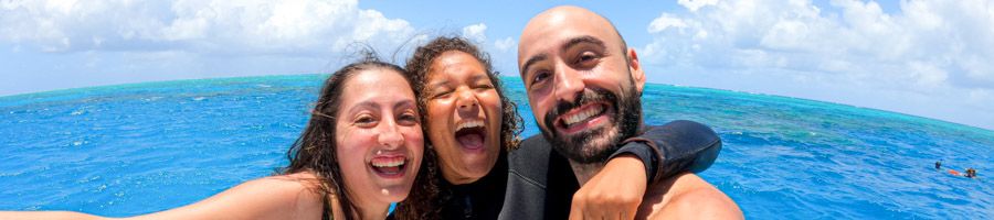 Three friends taking a fun selfie with the Great Barrier Reef in the background