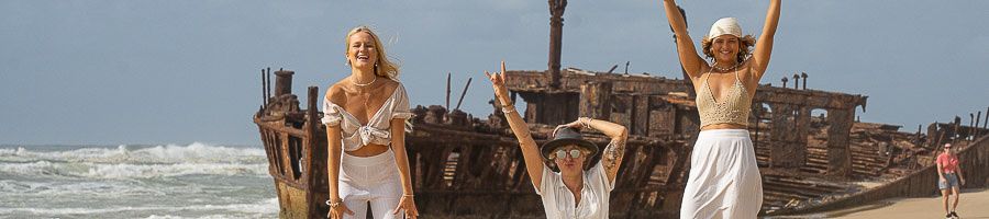 Maheno Shipwreck Three girls standing in front of a ship wreck