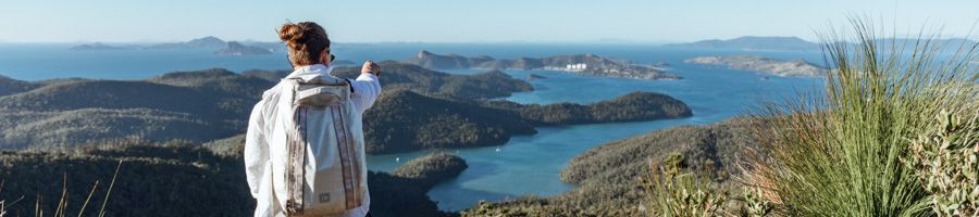 A man stood at Whitsunday Peak looking over towards Hamilton Island A man stood at Whitsunday Peak looking over towards Hamilton Island