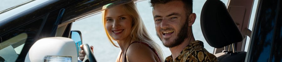 A man and a woman in the front of a car