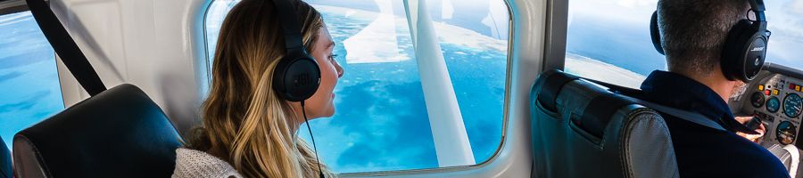 girl admiring views from a seaplane over the reef