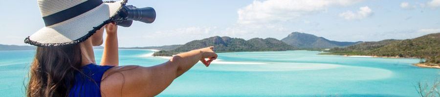 woman looking at hill inlet with binoculars