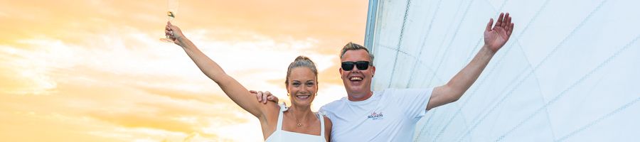 Whitsunday Sunset Sail couple posing in front of sails at sunset in the whitsundays