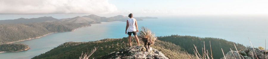 Man stood at the top of Whitsunday Cairn looking over the islands Man stood at the top of Whitsunday Cairn looking over the islands
