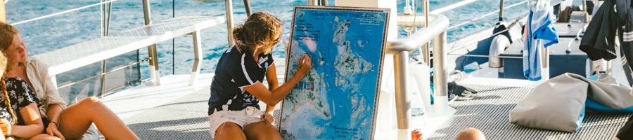 Whitsunday Navigating A crew member marking the navigational points on a map of the Whitsundays