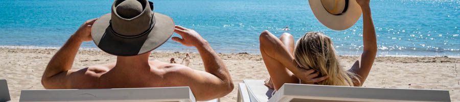Hamilton Island couple sunbathing on chairs on hamilton Island