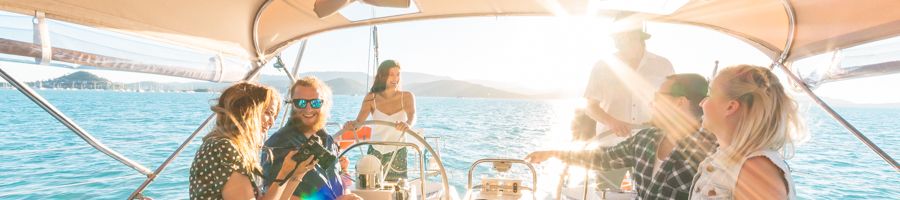Milady Sailing group smiling at the table on a sailboat