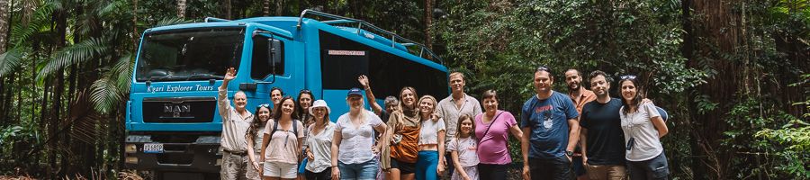 group tour in front of blue kgari explorer tours bus