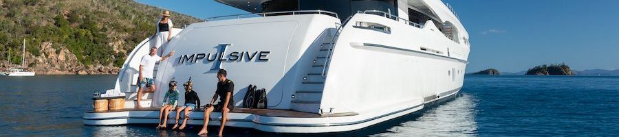 Impulsive Superyacht guests sitting on the back of impulsive superyacht in the whitsundays
