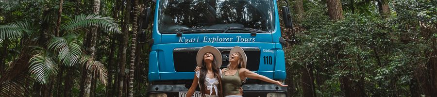 K'gari Explorer Tours Bus two girls posing in front of kgari explorer tours bus
