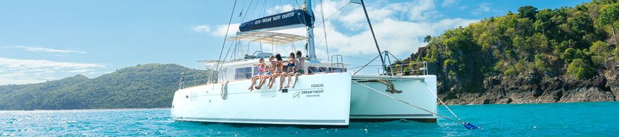 Whitsunday Pearl Catamaran White catamaran in the Whitsundays with people on the deck sitting