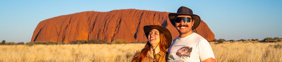 couple smiling at uluru in the red centre