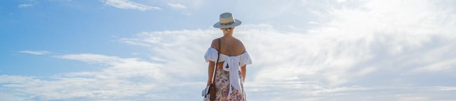 Noosa, Queensland, Australia A woman in a sunhat walking along the beach in Noosa, Queensland