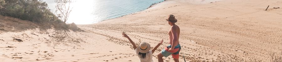 Carlo Sand Blow two travellers posing on the sand dunes in rainbow beach