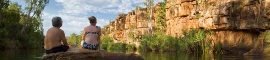 Water Hole Outback Australia two people sitting on rocks in a rugged water hole