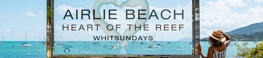 Airlie Beach, Queensland, Australia Woman standing at Airlie Beach sign