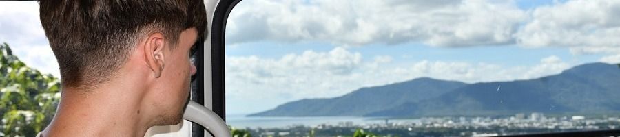 A tourist inside a shuttle bus driving through Cairns
