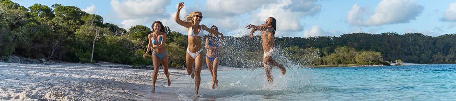 A group of four friends taking a dip in Lake McKenzie