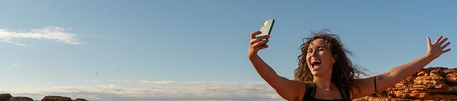 girl hiking through the outback and taking photos