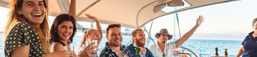 travellers with drinks smiling on milady yacht charter