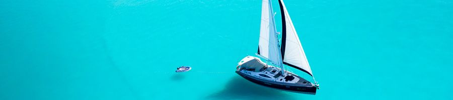 milady ship sailing over bright blue waters with tender