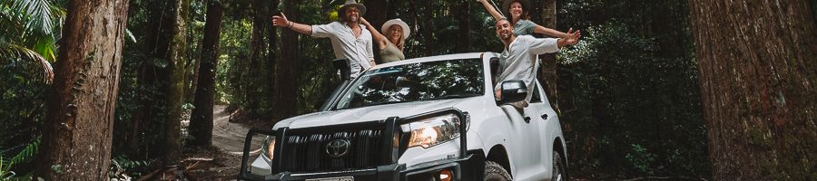 travellers posing in a white 4wd in the kgari forest