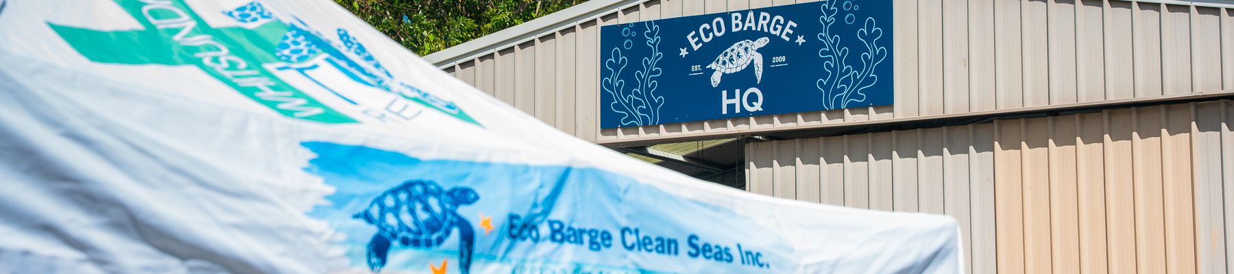 A tent that says Eco Barge next to a shed that says Eco Barge