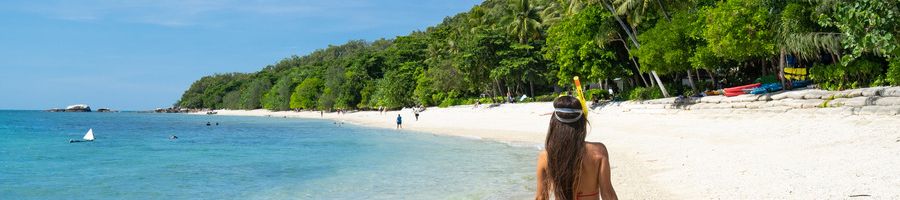 girl with snorkel walking on nudey beach fitzroy island