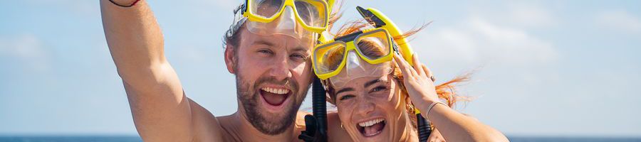 couple smiling with snorkel gear on green island