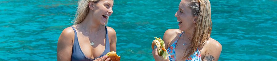 Lunch on a boat girls eating sandwiches on a boat on the water