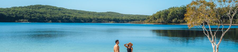 couple standing by the water at lake mckenzie