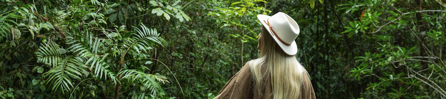 Daintree Rainforest a woman wearing a white hat walking through the rainforest