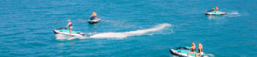 a drone shot of jetskis soaring through the ocean