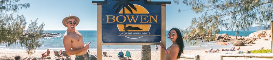 Bowen in Queensland, Australia A couple posing at the sign for Bowen near the beach
