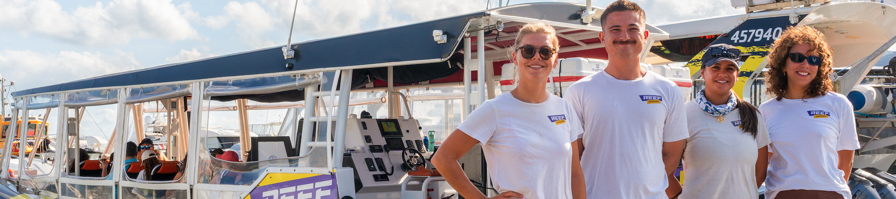 Reef Adventures four crew standing in front of their boat called reef adventures